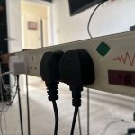 Surge protector mounted to the back of a desk.