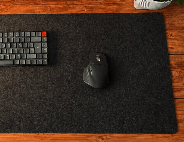 A desk pad with mouse and keyboard laying on it.