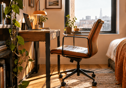 A small desk chair for a small enclosed space in front of a window.
